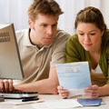 A couple researching their holiday on a computer