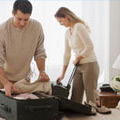 A couple packing clothes into a suitcase for their holiday